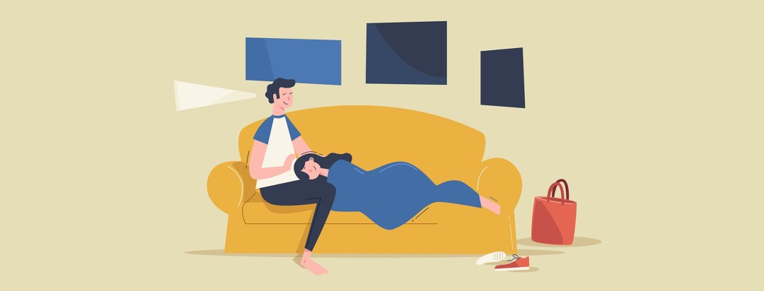 women laying down on couch next to man