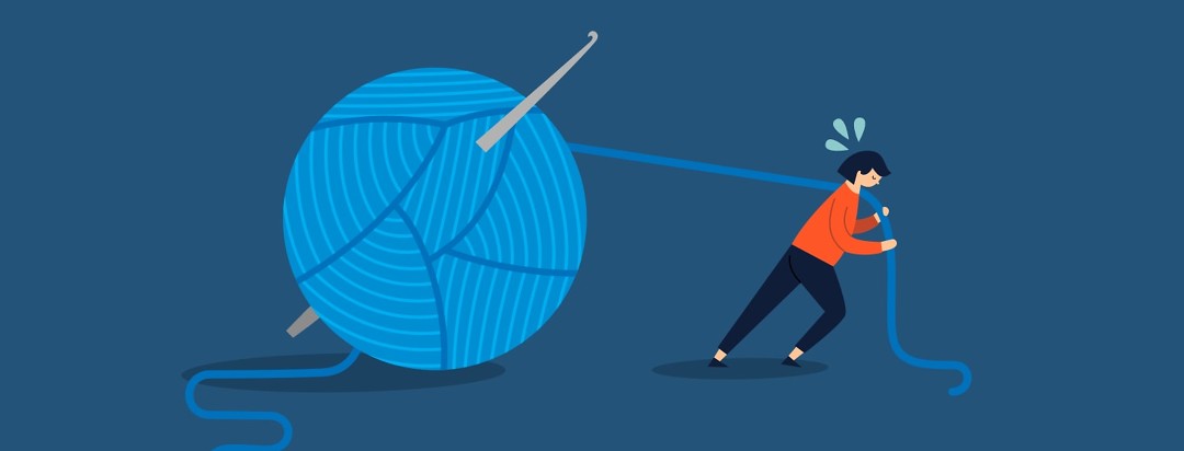 Woman struggling to drag a large ball of yarn along behind her