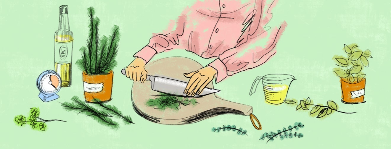 a woman in the kitchen chops fresh herbs from her herb garden