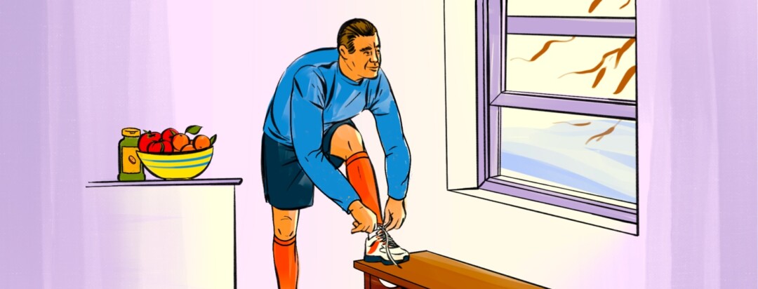 An man with tall compression socks on ties his shoe and looks out the window at the wintery scene
